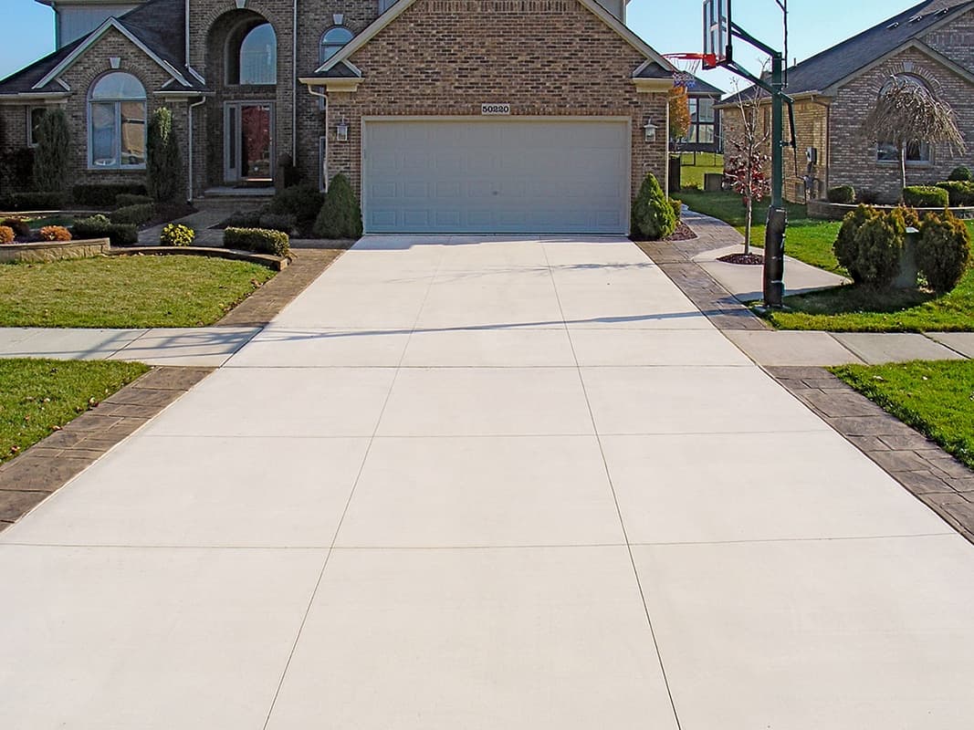 Completed concrete driveway with stamped borders by Woodstock Concrete Pros