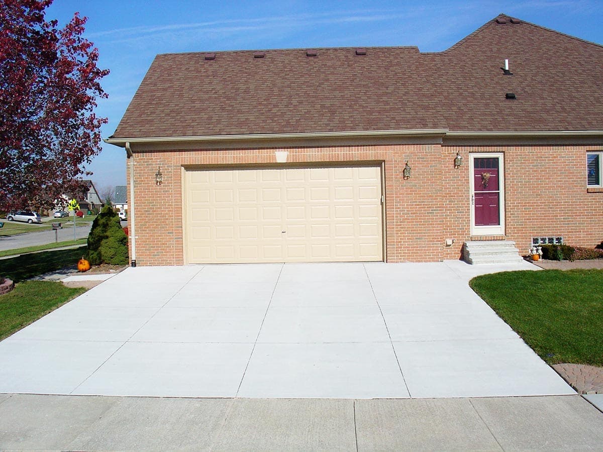 Clean concrete driveway with walkway leading to a brick home in Woodstock, Ontario